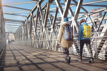 Fußgänger mit Rucksack überqueren eine Brücke in der Stadt