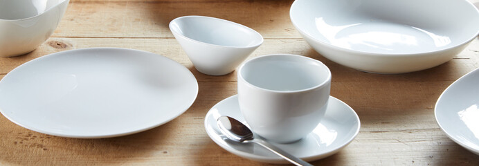 White cup on saucer and ceramic bowls