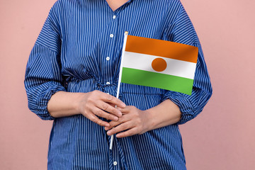 Niger flag. Close up of woman's hands holding Niger flag.