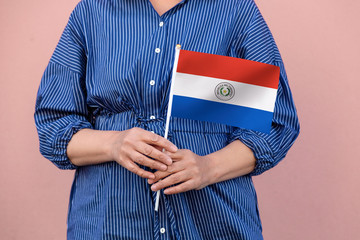 Paraguay flag. Close up of a woman's hands holding Paraguayan flag.	