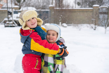 Fototapeta na wymiar Two happy little brothers in winter outside. two small boys in winter clothes.