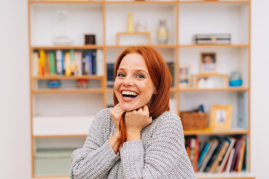 Laughing young redhead woman in her apartment
