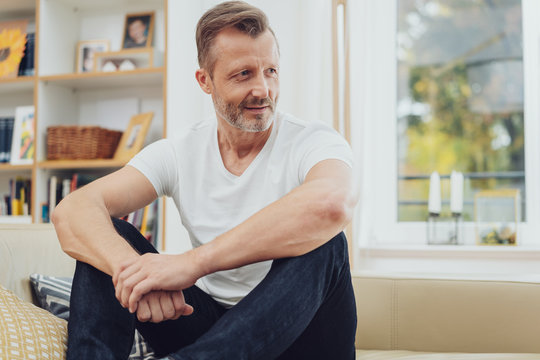 Relaxed mature man sitting on couch at home
