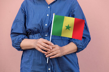 Senegal flag. Close up of a woman's hands holding Senegal flag.	