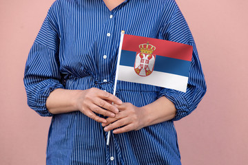 Serbia flag. Close up of a woman's hands holding Serbian flag.	