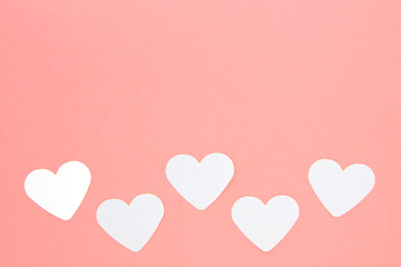 Fototapeta na wymiar White paper hearts on pink background with copy space