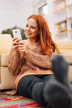 Woman on floor at home looking at her phone