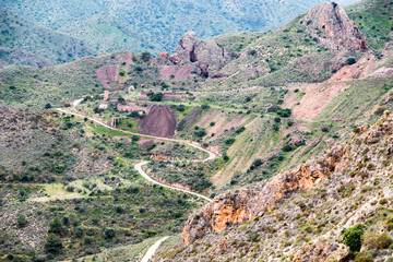 Fototapeta na wymiar Antigua zona minera del siglo pasado en las montañas de Vedar al borde de un río seco, cerca de Mojacar en Almería y ya en desuso.