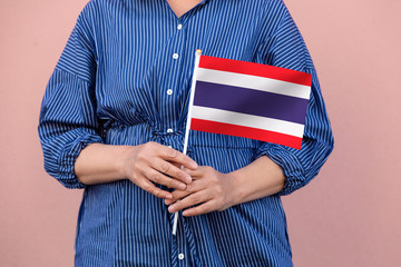 Thailand flag. Close up of a woman's hands holding Thai flag.	