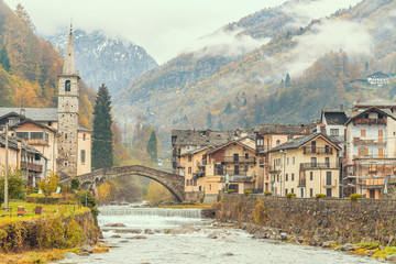 Fototapeta premium Fontainemore alpine village on the Lys river in a forest in the valley of Gressoney near Monte Rosa during autumn