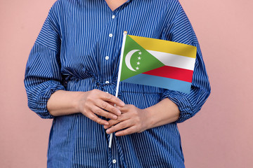 Comoros flag. Close up of a woman's hands holding Comoros flag.	