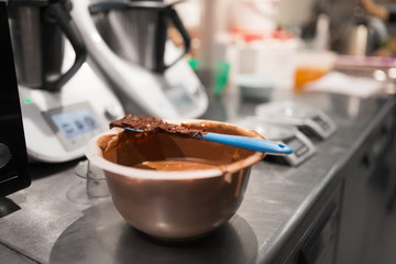 culinary and cooking concept - close up of chocolate cream in bowl at confectionery shop