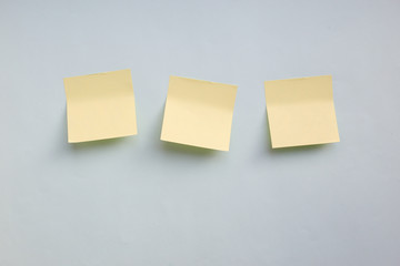 Three yellow paper stickers note with copy space on blue background