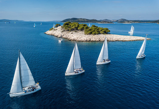 Amazing view of racing sailing boat with small island and crystal clear water