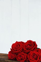 Group of lovely blooming red color rose flower on wood table with white background, sweet valentine present concept