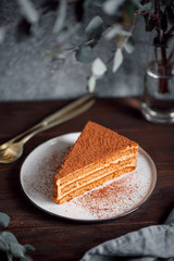 Piece of chocolate and walnut cake on a plate on a table.