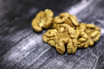 Walnuts on vintage dark wooden table. Peeled nuts close-up, background for healthy eating concept