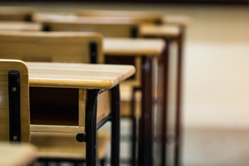 Lecture room or School empty classroom with desks chair iron wood for studying lessons in high school Thailand, interior of secondary education no kid teacher or young student with light flare
