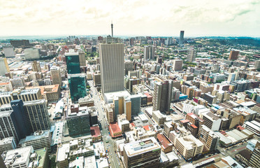 Obraz premium Widok z lotu ptaka na panoramę drapaczy chmur w biznesowej dzielnicy Johannesburga - Koncepcja architektury z nowoczesnym budynkiem w wielkim mieście RPA - Krajobraz na zdesaturowany dramatyczny filtr