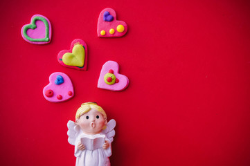 Cupid doll and heart-shaped on red background