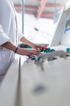 Detail of hands touching a machine of factory