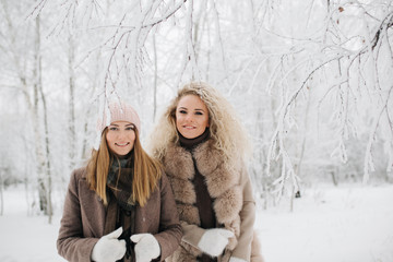 Photo of two blonde women on walk in winter forest