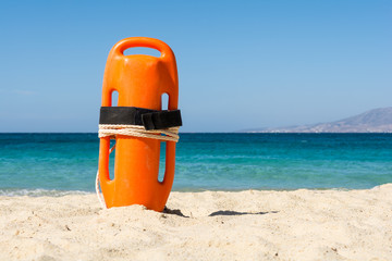 Orange rescue buoy on the beach - obrazy, fototapety, plakaty