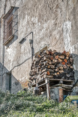 Firewood stacked in front of an old house