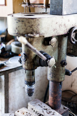 Metal industry stand with drill machine. Home workshop with hard tools on the metal stand. Old rusty hand tool drill machine on the metal stand