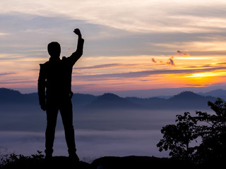 Silhouette of hiker man on top of mountain. successful people concept