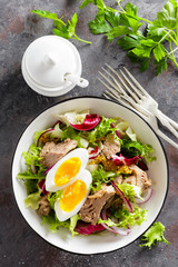 Diet food tuna salad with boiled egg, canned fish, onion and green lettuce top view