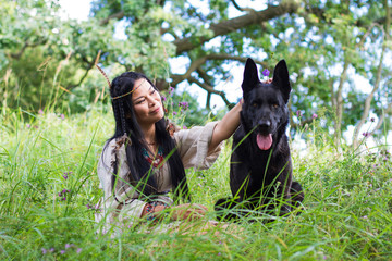 woman stroking a big dog sitting on the grass