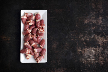 Podroby, serca kurczaka. Serca drobiowe na ciemnym  tle. © foodandcook