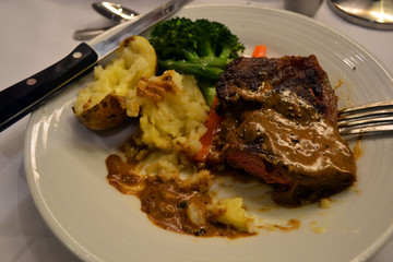 grilled steak with baked potato and vegetables