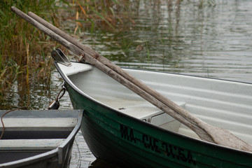 zielona łódź z wiosłami na tle jeziora