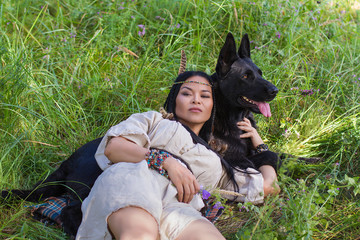 woman and dog are lying on the grass