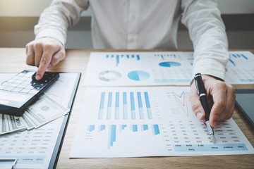 Finances Saving Banking Concept, Man accountant calculations income and analyzing financial graph data with calculator