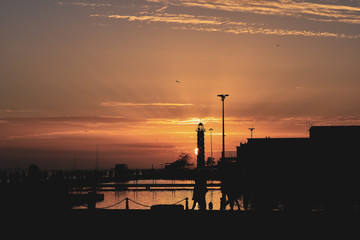 Beautiful sunset at Lisboa's port with the sun hidden in a lighthouse