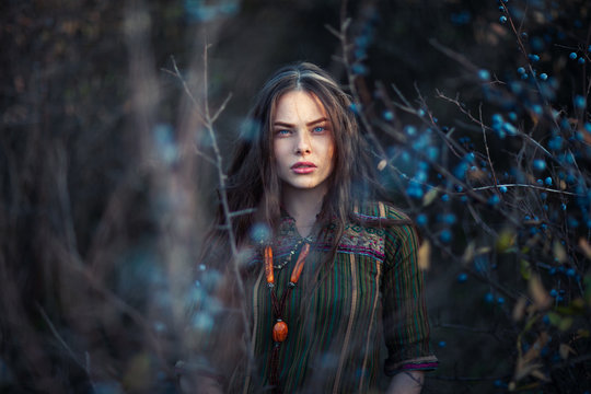 Fashion portrait of young boho girl at sunset posing on nature