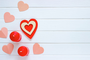 Wooden white background with red hearts and candles. The concept of Valentine Day. Top view.