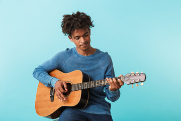 Handsome young african man playing a guitar
