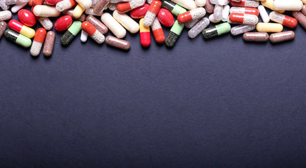 Medical pills on black background