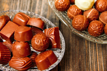 Chocolate candies in crystal bowl on old vintage rustic table