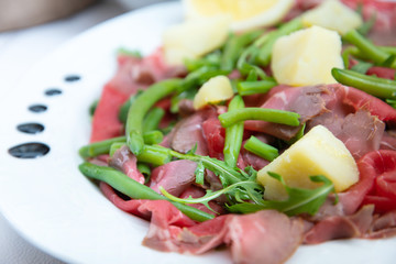 Fresh Sliced raw beef meat with leaf lettuce on the table
