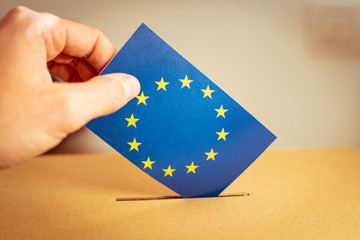 Election in European Union - voting at the ballot box. A hand putting an EU flag vote in the ballot...