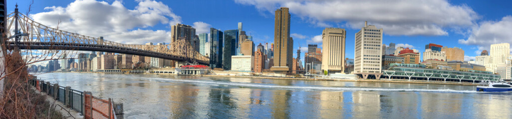 Fototapeta premium Panoramic view of Midtown Manhattan and East River from Roosevelt Island on a sunny day, New York City