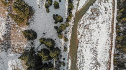 Aerial panoramic view of mountain valley in winter with snow, forest and river