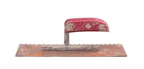Rusty old notched trowel on white