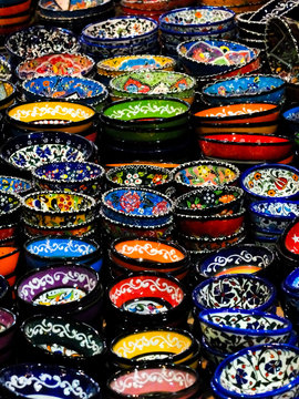 exposition with lot of coloured hand made touristic souvenir dishes for the table - asian and turkey colors and traditional