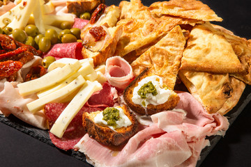 Assortimento di formaggi, verdure sott'olio e salumi italiani in primo piano